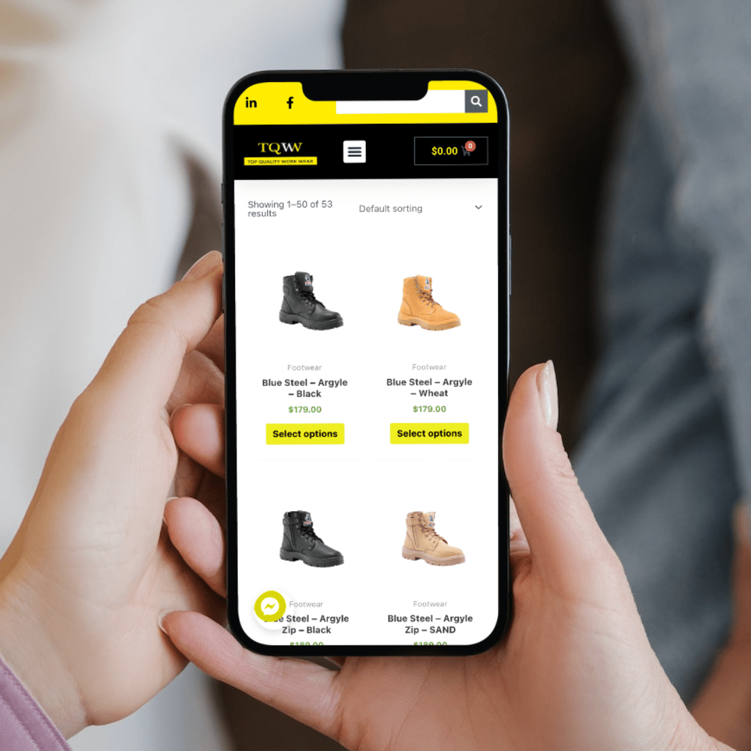 A woman showcasing a pair of boots using a smartphone for an ecommerce website design.