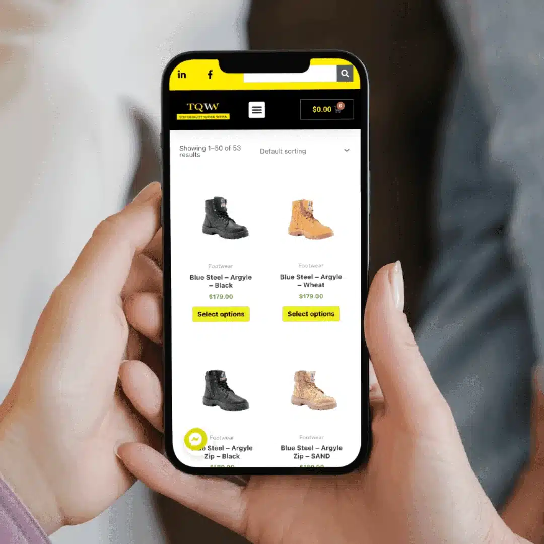 A woman showcasing a pair of boots using a smartphone for an ecommerce website design.