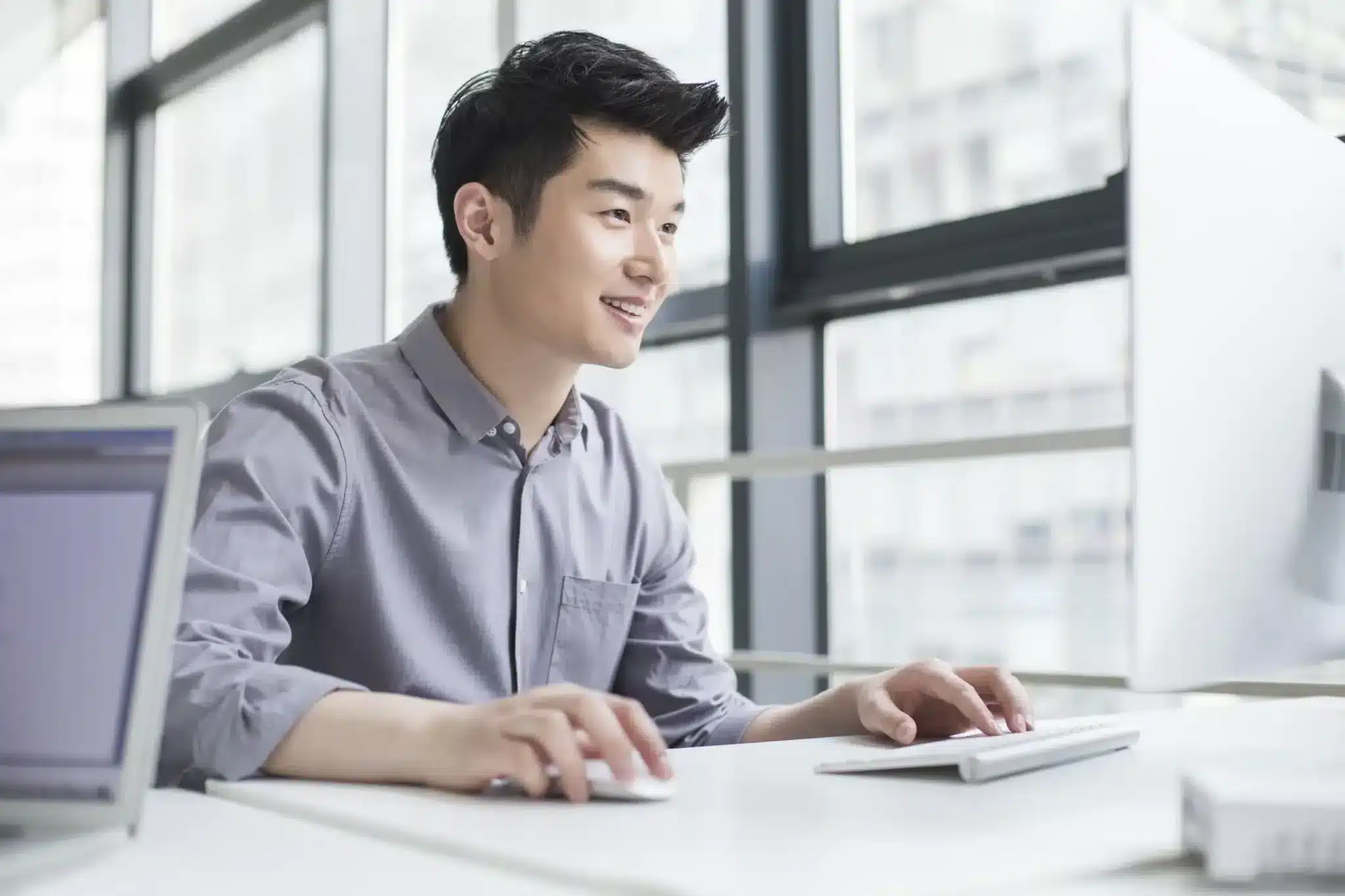 A man sitting in front of a computer screen.